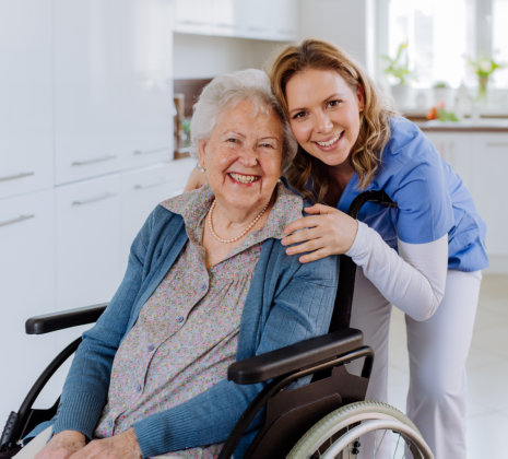 Woman Hugging Elderly Woman in Wheelchair